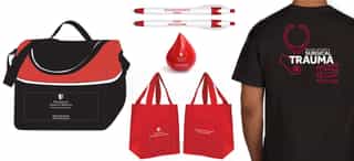 Stony Brook Medicine branded merchandise including t-shirts, tote bags, and pens.